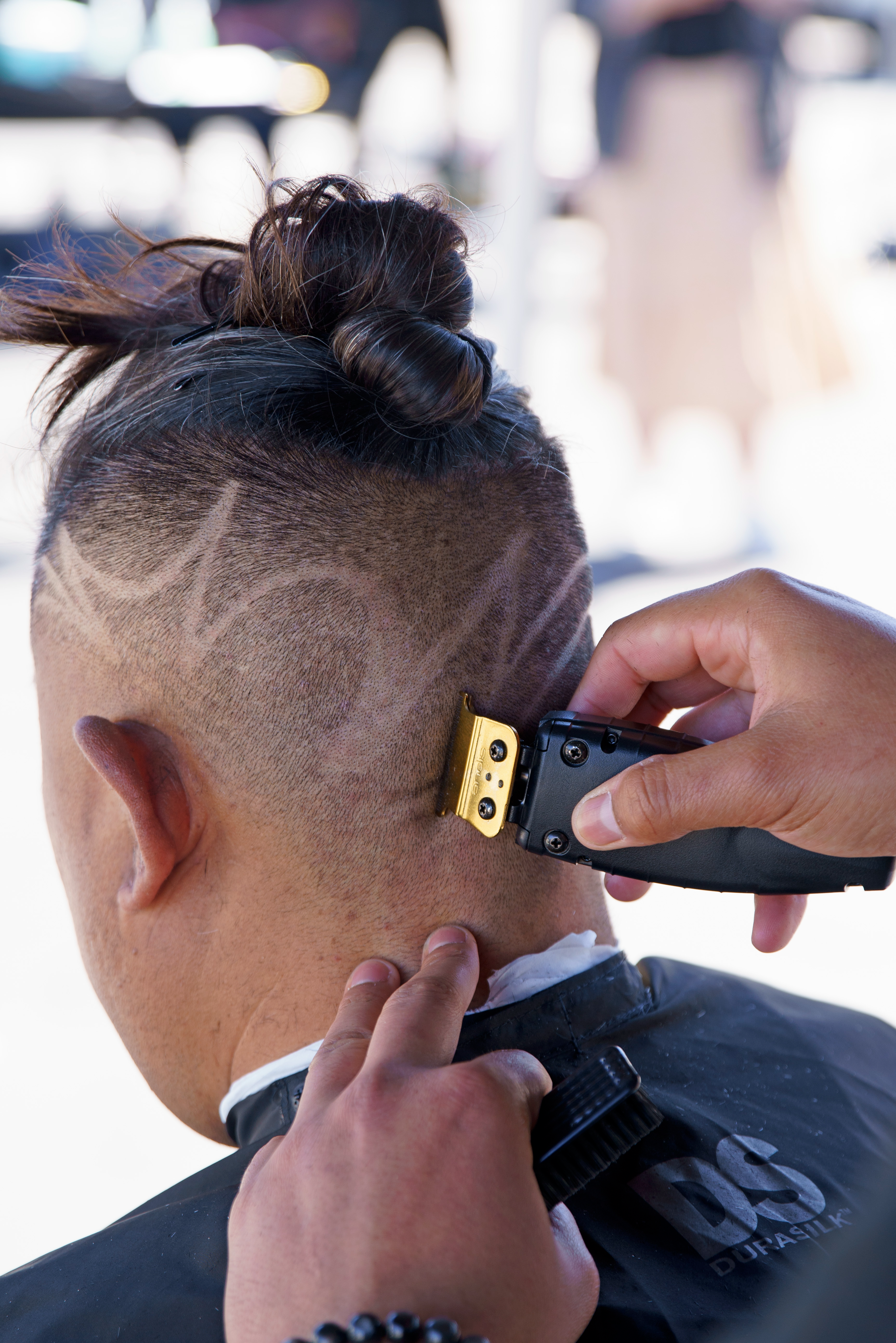 Brighter Community Venice Beach barber trimming designs in hair with GTO EXO trimmer