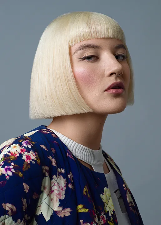 Blonde female model poses with Sharp Edge Undercut Bob hairstyle.